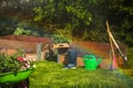 Wheelbarrow with Gardening tools in the garden. watering in the garden. rainbow formation Royalty Free Stock Photo