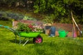 Wheelbarrow with Gardening tools in the garden. watering in the garden. rainbow formation Royalty Free Stock Photo