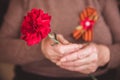 Concept background of May 9 russian holiday Victory Day. Old woman holding in hands a red carnation and St. George`s Royalty Free Stock Photo