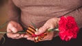 Concept background of May 9 russian holiday Victory Day. Old woman holding in hands a red carnation and St. George`s Royalty Free Stock Photo