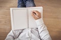 Man writing in a notebook on his lap.