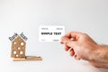 Concept of Bank investments and risks. A man`s hand holds a Bank card, and next to it is a mousetrap with a cardboard house with