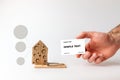 Concept of Bank investments and risks. A man`s hand holds a Bank card, and next to it is a mousetrap with a cardboard house with