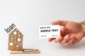 Concept of Bank investments and risks. A man`s hand holds a Bank card, and next to it is a mousetrap with a cardboard house with