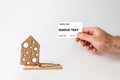 Concept of Bank investments and risks. A man`s hand holds a Bank card, and next to it is a big mousetrap with a cardboard house