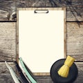 Concept of Barber Shop. Set of hairdressing tools and blank white sheet for text on a wooden background. Copy space. Royalty Free Stock Photo