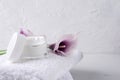 Concept of beauty treatments. White towels, violet callas, moisturuzing cream. Empty space for design Royalty Free Stock Photo