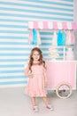 The concept of birthday and happiness - a happy little girl is standing in a beautiful dress on the background of Candy Bar. Decor Royalty Free Stock Photo