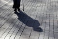 Silhouette and shadow of woman walking with a cane