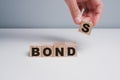 Concept of bonds. Businessman puts wooden blocks with the word Bonds. Equivalent loan. Unsecured and secured bonds. Bonds