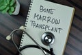 Concept of Bone Marrow Transplant write on a book with stethoscope isolated on Wooden Table Royalty Free Stock Photo