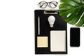 Concept brainstorming. Creative top view flat lay of desk with clipboard, pen, monstera leaves, eyeglasses, notebook