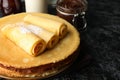 Concept of breakfast with crepes with chocolate paste on black smokey table