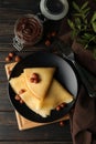 Concept of breakfast with crepes with chocolate paste and nuts on wooden table