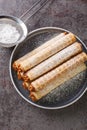 Concept of breakfast with wafer rolls with condensed milk closeup in plate. Vertical top view Royalty Free Stock Photo