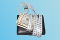 Concept of budget and money. Money with purse is tied with measuring tape