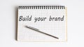 Concept BUILD YOUR BRAND message on the notebook on white background