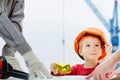 Concept, builders are discussing with child over drawing. Helmet protective equipment construction city site, cranes Royalty Free Stock Photo