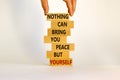 Businessman hand. Wooden blocks with words nothing can bring you peace but yourself.