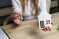 Realtor`s hands holding house keys and house model. Royalty Free Stock Photo