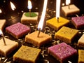 A Bunch Of Small Square Cakes With Lit Candles. Generative AI
