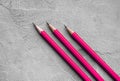 Concept of business, Back to school, three sharpened pencils on a background of gray plaster texture, space for text Royalty Free Stock Photo