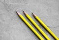 Concept of business, Back to school, three yellow sharpened pencils on a background of gray plaster texture, space for text Royalty Free Stock Photo