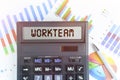 On the table are financial charts and a calculator, on the electronic board of which is written the text - WORKTEAM