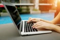 Close up portrait of woman hands pressing keyboard buttons on laptop sunny day swimming pool Royalty Free Stock Photo