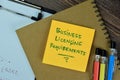 Concept of Business Licensing Requirements write on sticky notes isolated on Wooden Table