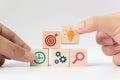 Hand putting wooden cube block stacking with icon on white background Royalty Free Stock Photo