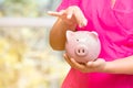 Concept business woman hand putting money coin into piggy bank saving money for future plan and retirement fund, Royalty Free Stock Photo