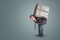 Businessman bending under a heavy stone with the German word `Schulden` written on it