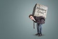 Businessman bending under a heavy stone with the words `Student Loan` written on it