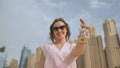 The concept of buying an apartment. Girl holds the keys to a new house against the backdrop of skyscrapers in the city. Royalty Free Stock Photo