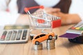 Concept of buying new car by money with red shopping cart, calculator and magnetic card. Royalty Free Stock Photo