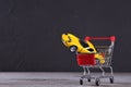 Concept of buying a new car. Toy car in shopping basket on wooden background Royalty Free Stock Photo