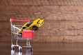 Concept of buying a new car. Toy car in shopping basket on wooden background Royalty Free Stock Photo