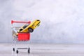 Concept of buying a new car. Toy car in shopping basket on wooden background Royalty Free Stock Photo