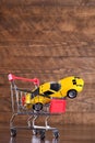 Concept of buying a new car. Toy car in shopping basket on wooden background Royalty Free Stock Photo