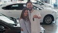 The concept of buying or renting a car. Young happy interracial couple with new car keys. Royalty Free Stock Photo