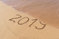 2019 handwritten text on sandy beach with flush wave