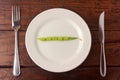 Concept of calorie restriction. Strict diet. Small bunch of American broccoli isolated on white dish with fork and knife