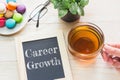 Concept Career Growth message on wood boards. Macaroons and glass Tea on table.