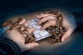 Close-up of hands, computer keyboard and old rusty chains on dark wooden background Royalty Free Stock Photo