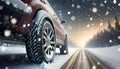 Concept of changing tires on car wheels when winter begins. Close-up of rear wheels of a car driving at speed on a snowy