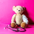 Concept of child playing doctor with teddy bear, pink background Royalty Free Stock Photo