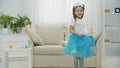 Cute little princess in crown is turning around in beautiful dress, smiling, giving anb airkiss at the camera.