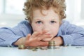 Young boy build a tower by coins. Royalty Free Stock Photo