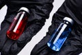 Concept of choice treatment. Close up Doctor hands holding two ampoules. Medical ampoules with liquid. Red and blue ampoules.